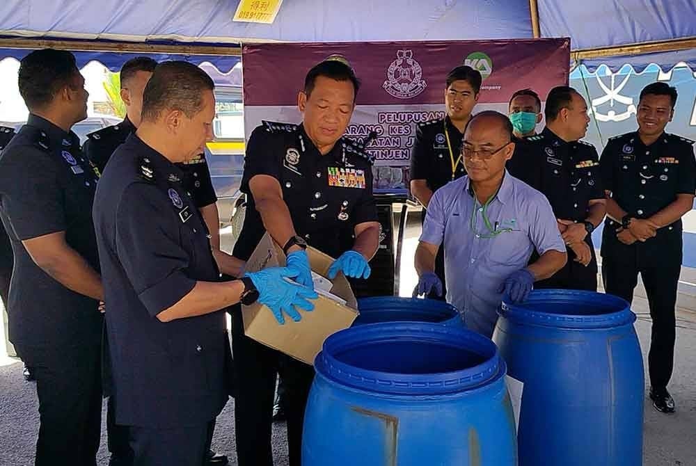Yahaya (depan, tengah) memasukkan dadah yang akan dilupuskan.