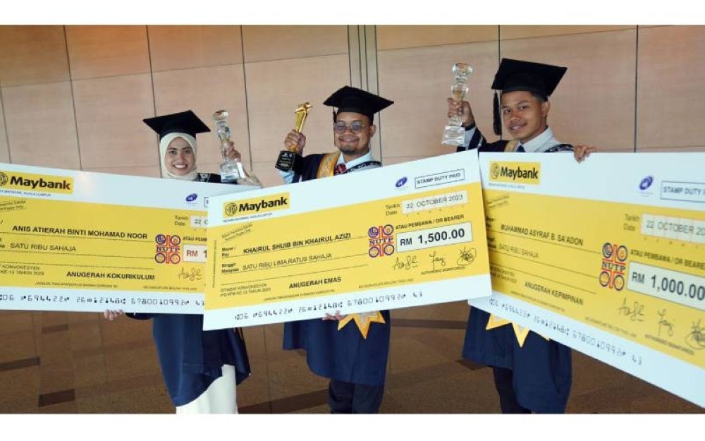 Khairul Shuib (tengah), Muhammad Asyraf (kanan) dan Anis Atierah menunjukkan trofi serta replika cek yang diterima masing-masing sempena Istiadat Konvokesyen IPG KPM Kali ke-13.