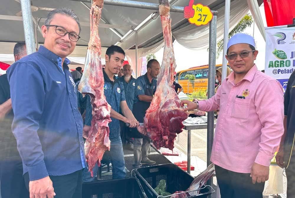 Hanifa (kiri) dan Tuan Mohd Saripudin (kanan) melawat ke gerai jualan daging di Karnival Jualan Agromadani LLP di Tunjong, Kota Bharu.