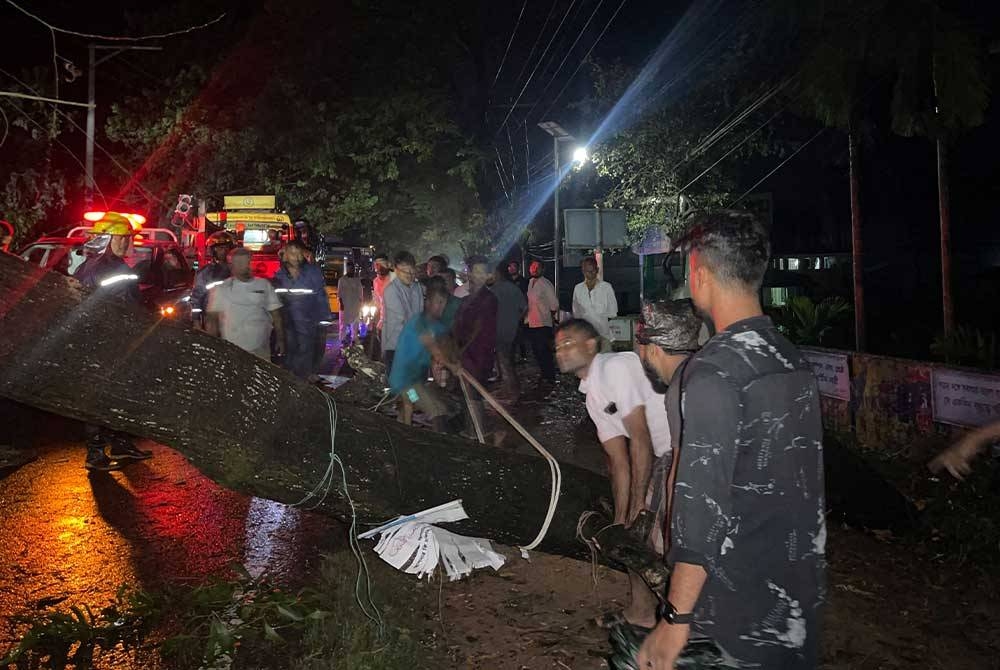Lelaki Bangladesh memotong pokok tumbang untuk membersihkan jalan yang tersekat di Cox’s Bazar pada awal pagi selepas taufan Hamoon melanda. - Foto AFP