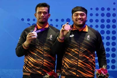 Ziyad Zulkifli (kanan) bersama Mohamad Aliff menunjukkan pingat dimenangi dalam acara akhir Lontar Peluru F20 Sukan Para Asia Hangzhou 2022 di Stadium Huang Long pada Selasa. - Foto Bernama