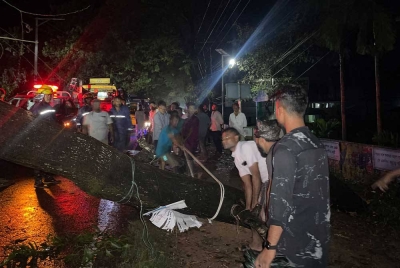 Lelaki Bangladesh memotong pokok tumbang untuk membersihkan jalan yang tersekat di Cox’s Bazar pada awal pagi selepas taufan Hamoon melanda. - Foto AFP