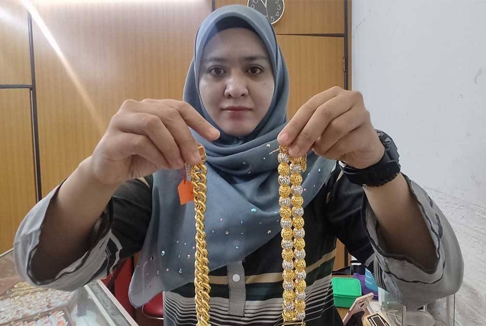 Syarafina Atirah menunjukkan antara barangan kemas terbaharu yang dijual di Kedai Emas Seri Pekan Rabu, Alor Setar.