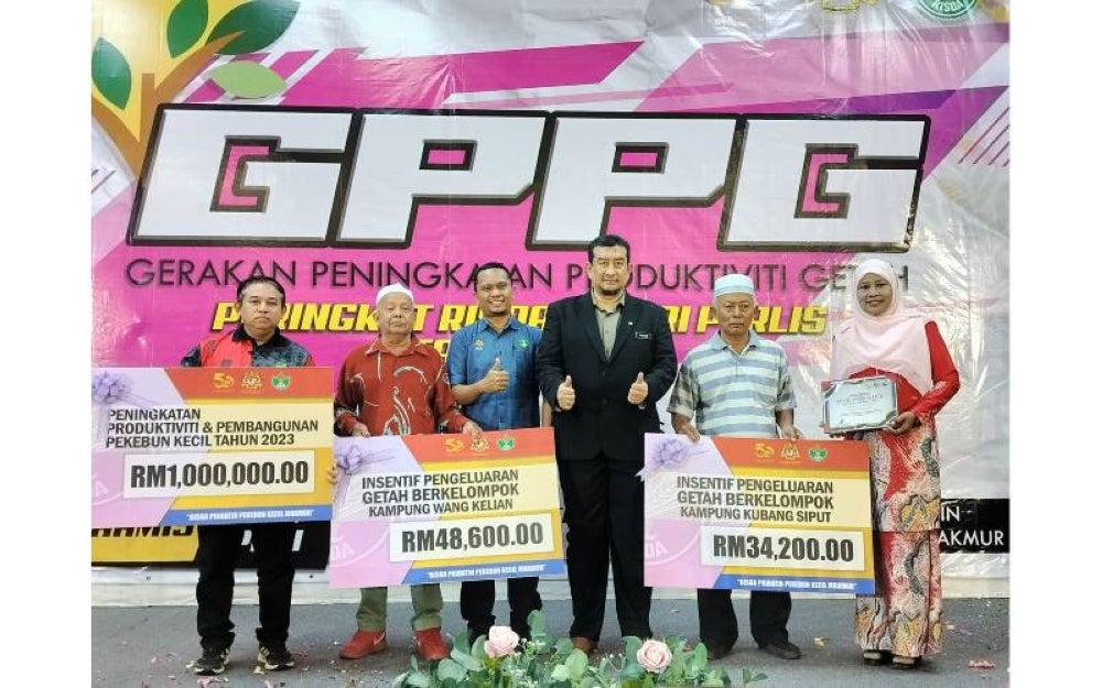 Ruzaini (tiga dari kanan) bergambar bersama para penerima cek dan Anugerah Model Pekebun Kecil sempena Program Gerakan Peningkatan Produktiviti Getah (GPPG) Peringkat Negeri Perlis di Padang Besar, Perlis pada Khamis.