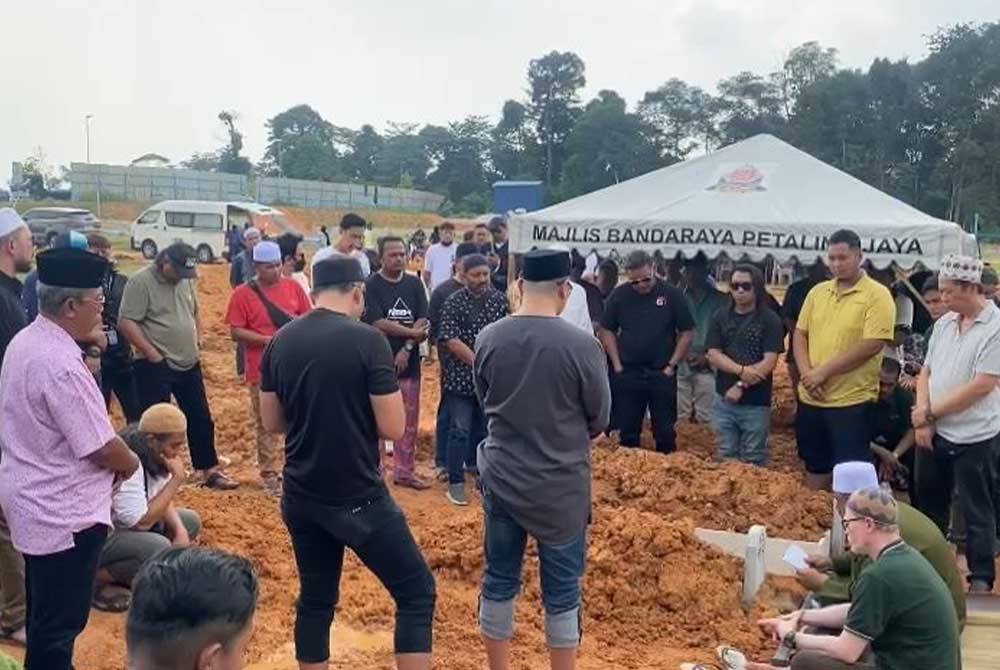 Hafizal (duduk, kanan) merupakan waris terdekat kepada Allahyarham Badrul Izhan Yeop Abdullah atau Bad Indigo di Tanah Perkuburan Islam Seksyen 9, Kota Damansara pada Jumaat.