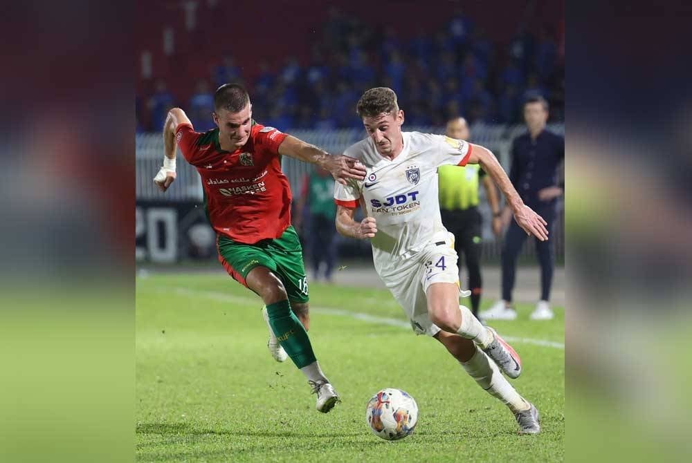 Pemain JDT, Oscar Pasero Arribas (kanan) diasak pemain Kelantan United FC, Dominik Balic dalam aksi perlawanan Liga Super di Stadium Sultan Muhammad Ke-IV malam ini. - Foto Bernama