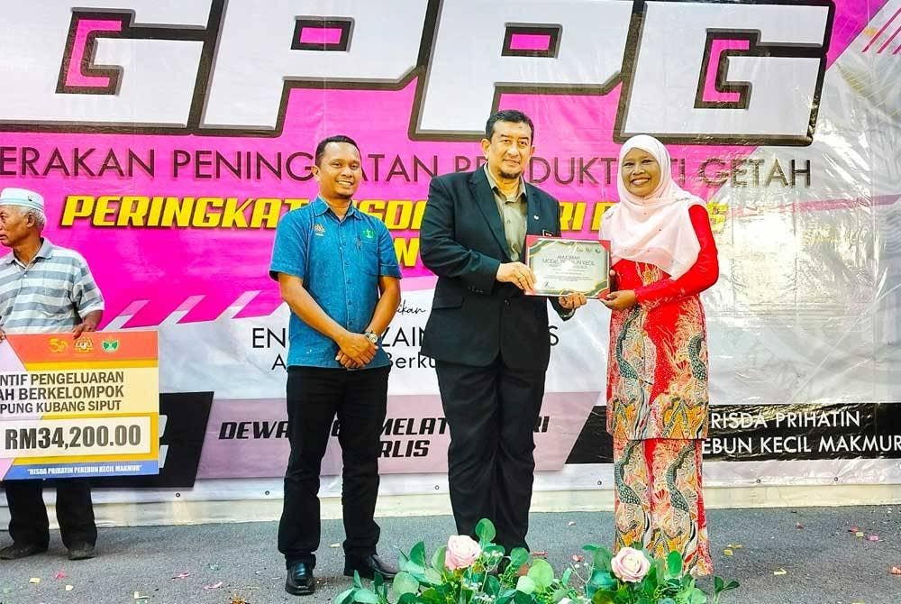 Che Amah menerima Anugerah Model Pekebun Kecil RISDA negeri Perlis daripada Ahli Pihak Berkuasa RISDA, Ruzaini Rais pada Program Gerakan Peningkatan Produktiviti Getah (GPPG) Peringkat RISDA negeri Perlis, Khamis lalu.
