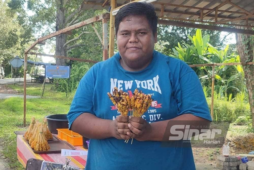 Muhammad Khairul Fikri menunjukkan sate ayam dijual di gerainya di Jalan Kampung Padang, Jitra.