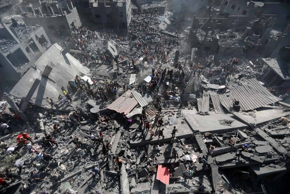 Orang ramai mencari mangsa yang terselamat di antara runtuhan bangunan yang musnah dalam serangan udara Israel di bandar selatan Genting Gaza. Foto Xinhua