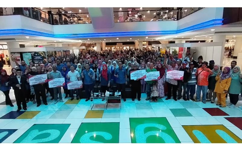 Noraini (bertudung merah) bergambar bersama para pekebun kecil getah sempena Karnival Gerakan Peningkatan Produktiviti Getah (GPPG) 2023 di Plaza Angsana, Johor Bahru pada Sabtu.