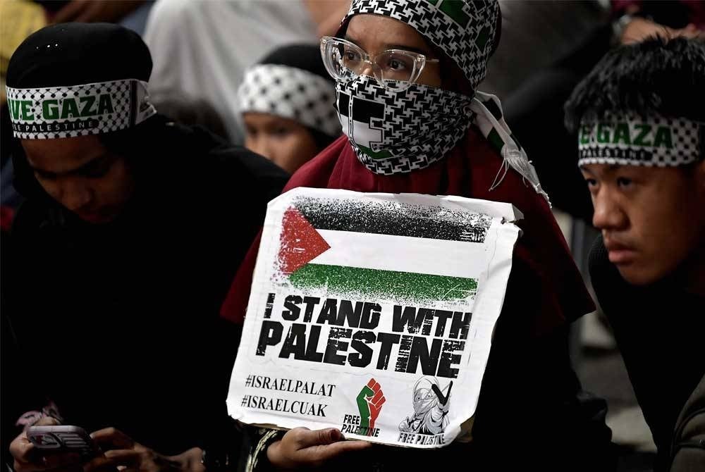 Orang ramai sepanduk sebagai tanda menyatakan solidariti terhadap rakyat negara itu pada Himpunan Solidarity 4 Palestine di Dataran Kemerdekaan Shah Alam. - Foto Bernama