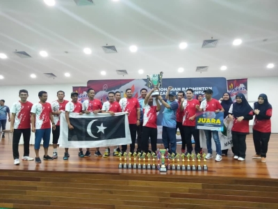 Abdul Hakim (lapan kanan) menyerahkan piala pusingan kepada pasukan Maidam selepas dinobatkan sebagai juara Kejohanan Badminton Zakat Cup di Arena Sukan Kuala Lumpur