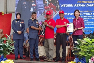 Sandrea (kanan) dan Abdul Wahab (dua dari kiri) memyampaikan sijil pendaftaran Pasukan Bomba Komuniti pada Karnival Keselamatan Kebakaran peringkat JBPM Negeri Perak di Ipoh pada Ahad.
