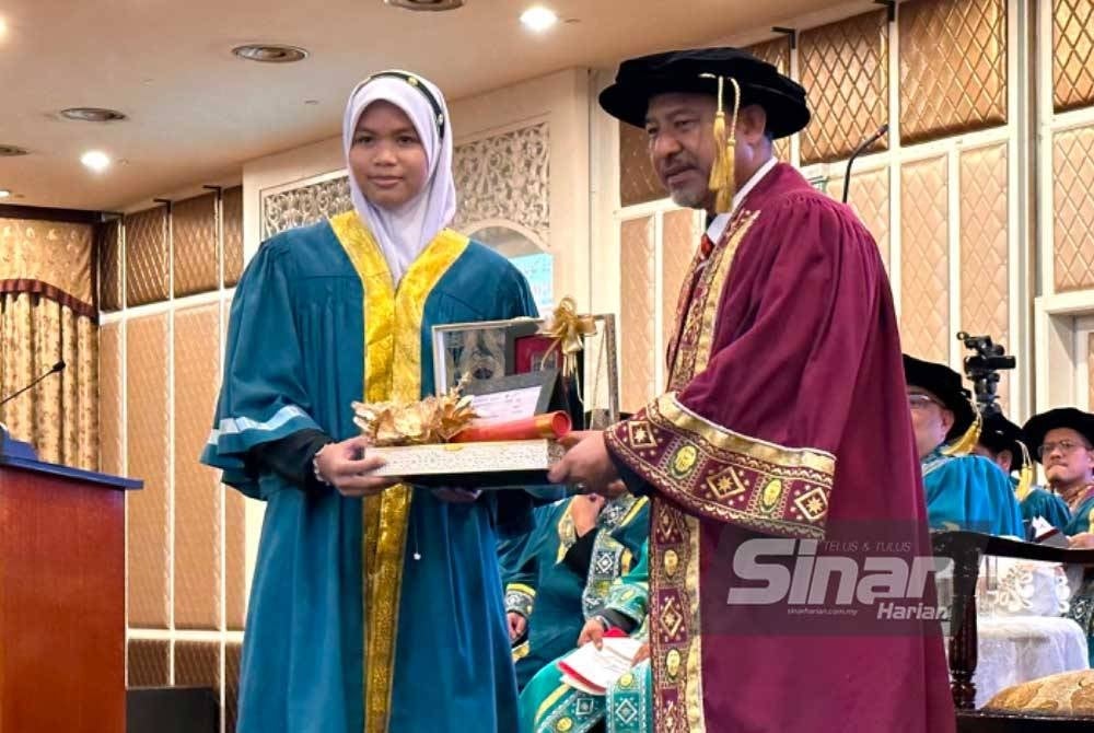 Izzah (kiri) menerima anugerah yang disampaikan oleh Mohd Nassuruddin (kanan).