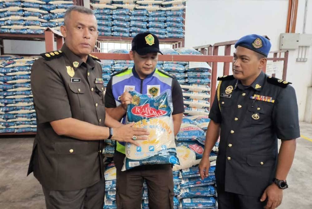 Hamizan (kanan) menunjukkan sample beras sebelum dibawa ke MARDI untuk dibuat analisis ketika menjalankan operasi di kilang beras Mumtaz Iman di Indera Mahkota pada Isnin.