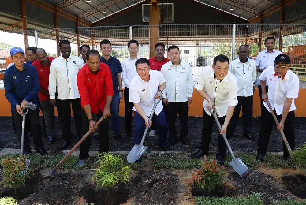 Kor Ming (tengah) menyempurnakan acara menanam pokok ketika lawatan kerjanya ke gelanggang badminton di Kampung Baru Sungai Buloh sempena Program Sentuhan Kasih KPKT ke Sungai Siput pada Isnin.