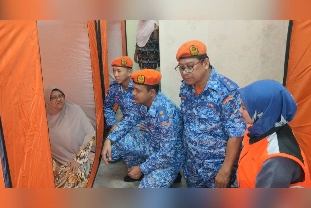 Zairil Anuar (tengah) memantau keadaan PPS Dewan Orang Ramai Kampung Bukit Belah, Sungai Petani pada Isnin.