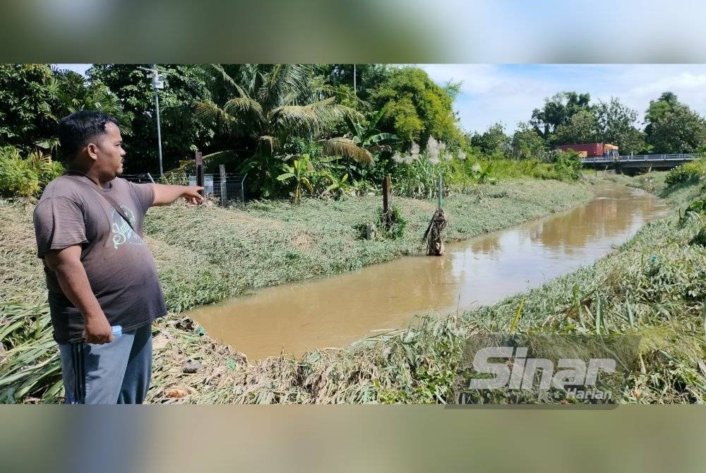 Mohd Ridzuan menunjukkan kadaan sungai yang semakin cetek dikhuatiri tidak mampu menampung kapasiti air yang besar sehingga menyebabkan sering berlaku banjir kilat di Kampung Bukit Belah.