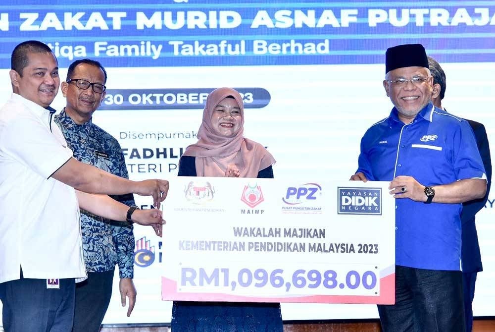 Fadhlina (tengah) menyaksikan penyerahkan zakat oleh PPZ-MAIWP di KPM di Putrajaya pada Isnin.