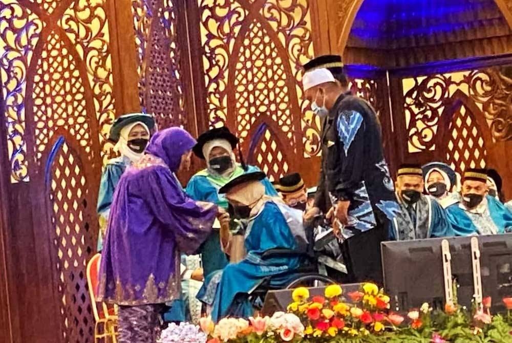 Harniza (berkerusi roda) ketika menerima skrol disampaikan oleh Permaisuri Agong Tunku Hajah Azizah Aminah Maimunah Iskandariah sempena Konvokesyen Universiti Islam Antarabangsa Malaysia (UIAM) ke-37 pada 13 Ogos 2022.