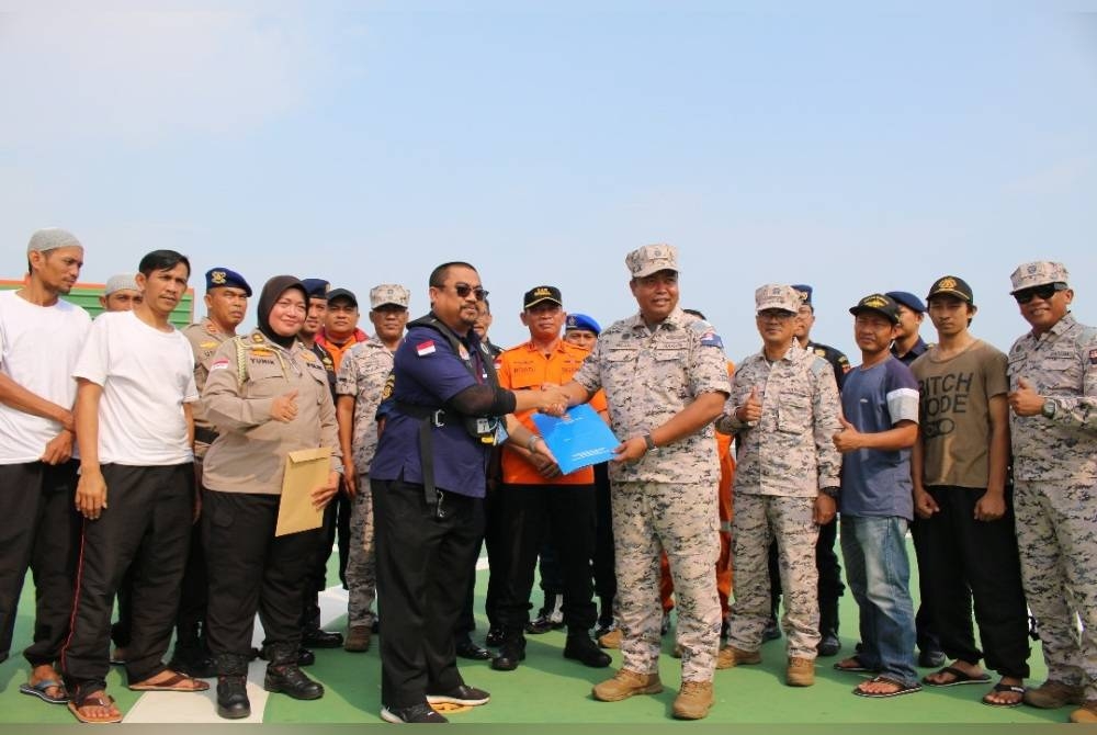 Nurul Hizam (kanan) bersama Slamet ketika menyerahkan kesemua mangsa di atas kapal KN SAR Purwojero 101 milik Badan Nasional Pencarian dan Pertolongan (Basarnas), pada petang Isnin. - Foto Maritim Malaysia Johor