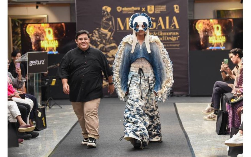 Mohamad Hilmi (kiri) memperlihatkan busana rekaannya yang berjaya memenangi hadiah utama acara ‘Waste is Amazing Fashion Show 2023’