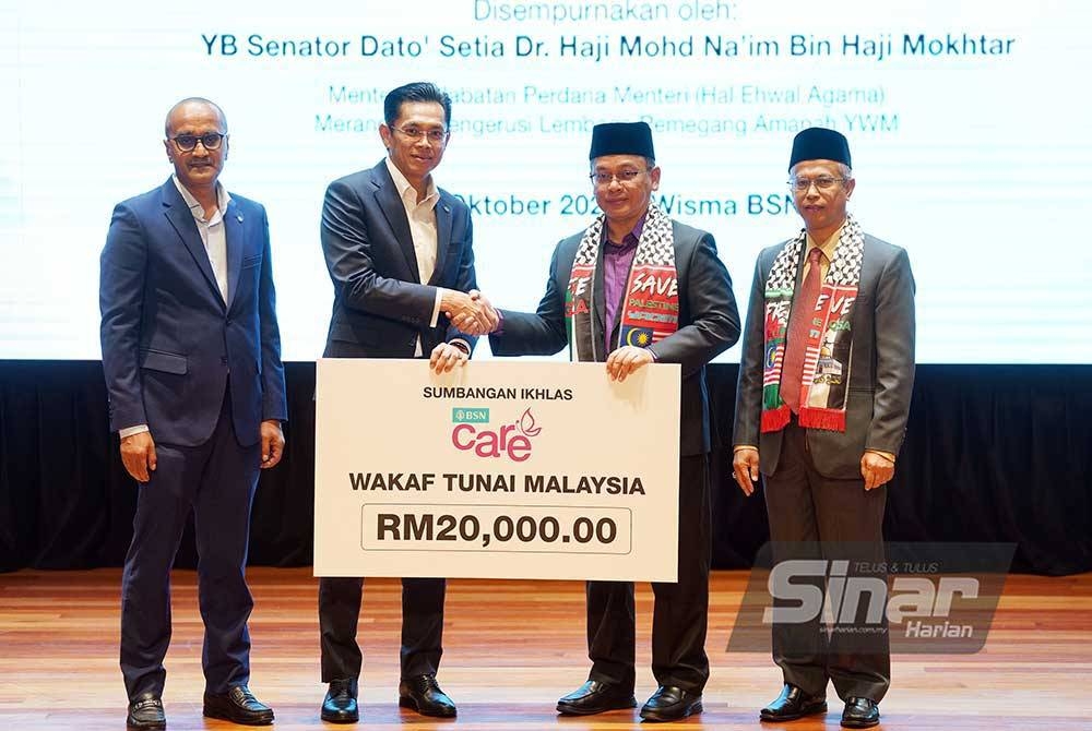Mohd Na'im menerima sumbangan dari Ketua Eksekutif Bank Simpanan Nasional, Jay Khairil disaksikan oleh Ketua Pegawai Eksekutif Yayasan Waqaf Malaysia, Dr. Ridzwan Bakar (kanan) dan Ketua Pegawai Perniagaan Bank Simpanan Nasional, Mujiburrahman Abdul Rashid (kiri) pada majlis Pelancaran Kerjasama Strategik Wakaf Tunai Malaysia Antara Bank Simpanan Nasional Dan Yayasan Waqaf Malaysia yang diadakan di Wisma BSN, Kuala Lumpur pada Selasa. - Foto Sinar Harian/Rosli Talib