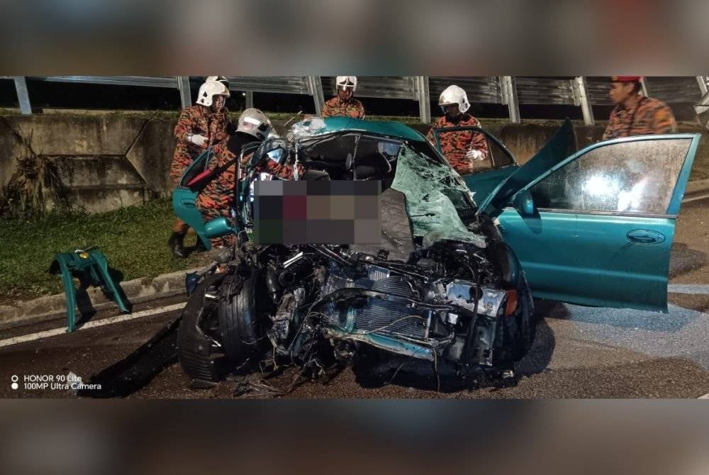 Anggota bomba mengeluarkan mangsa kemalangan yang tersepit.