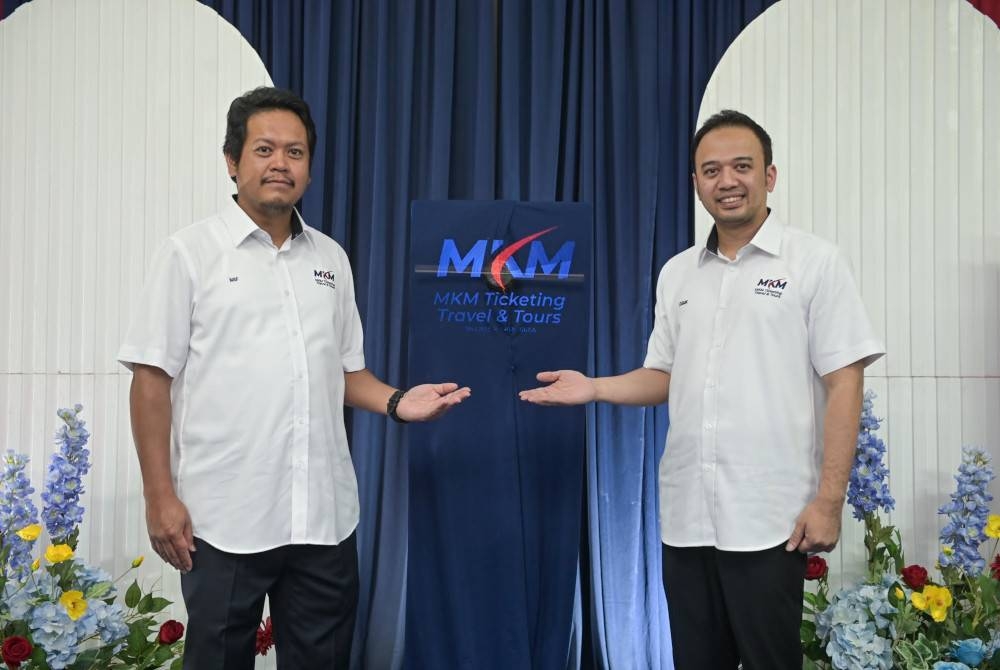 Mohd Khairi (kanan) dan Ketua Pegawai Operasi MKM, Nik Shazni Farhan Nik Mohammad Shah bergambar bersama logo baharu MKM.