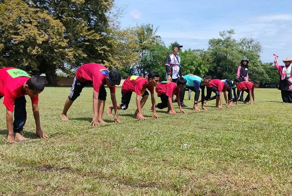 Peserta yang mengambil bahagian dalam acara larian 200 meter lelaki bersedia untuk dilepaskan.