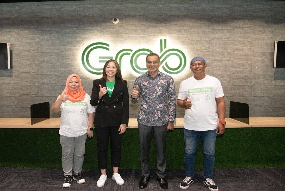 Mohammed Azman (dua dari kanan) ketika menghadiri pelancaran Program Tajaan Caruman Skim Keselamatan Sosial Pekerjaan Sendiri (SKSPS) PERKESO kepada rakan penghantar Grab Malaysia, di Grab Driver Centre (GDC) di Petaling Jaya pada Khamis.