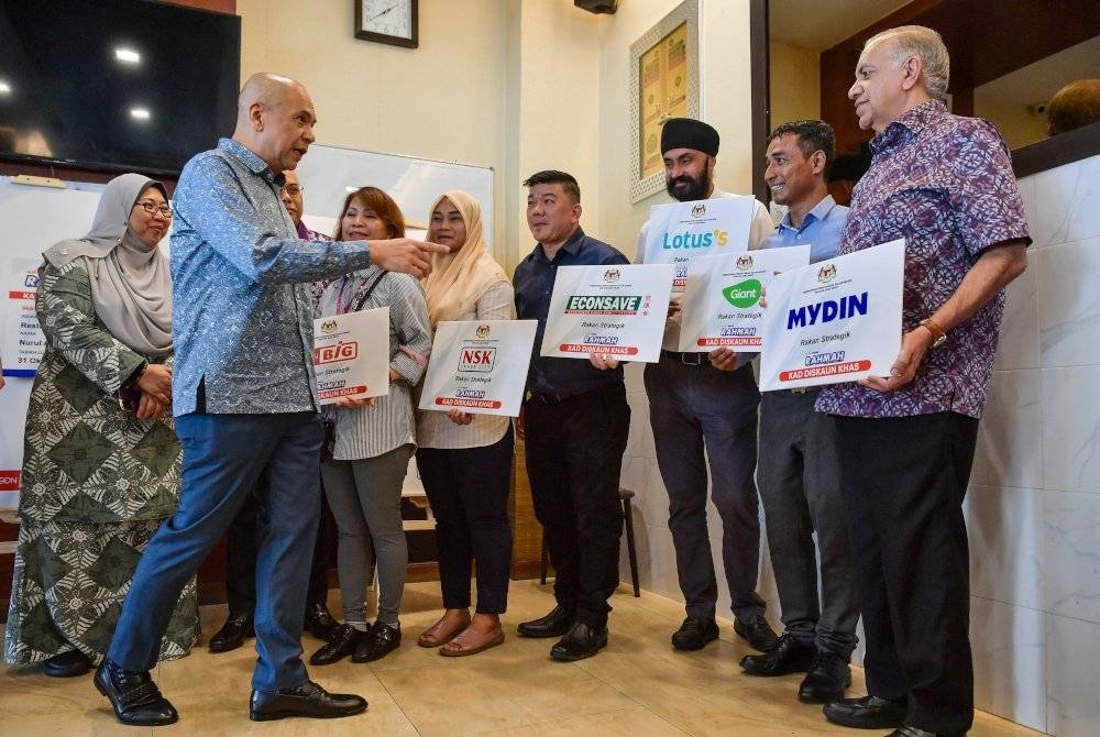 Armizan (kiri) beramah mesra bersama wakil pengusaha pasaraya yang menawarkan permohonan Kad Diskaun Khas Menu Rahmah di Restoran Ali Maju.Turut hadir, Timbalan Menteri Perdagangan Dalam Negeri dan Kos Sara Hidup, Fuziah Salleh. - Foto Bernama