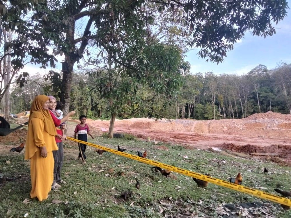 Siti Rohani (kanan) dan Anies Asiykin menunjukkan lokasi kejadian tiga warga Bangladesh ditemukan tertimbus.