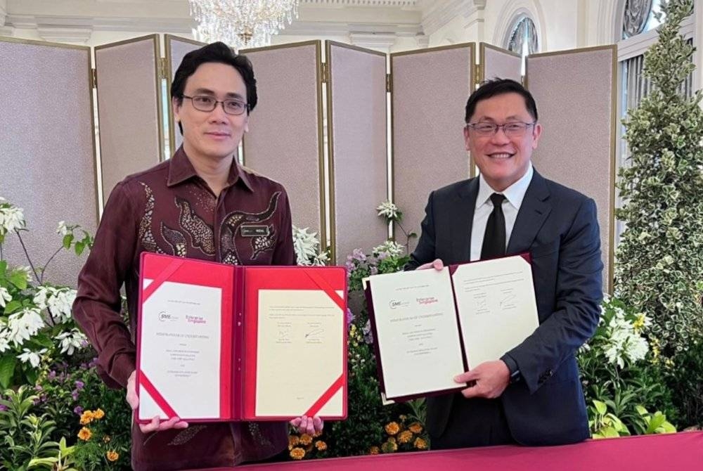 Pertukaran MoU antara Rizal (kiri) dan Ketua Pegawai Eksekutif Enterprise Singapore, Lee Chuan Teck.