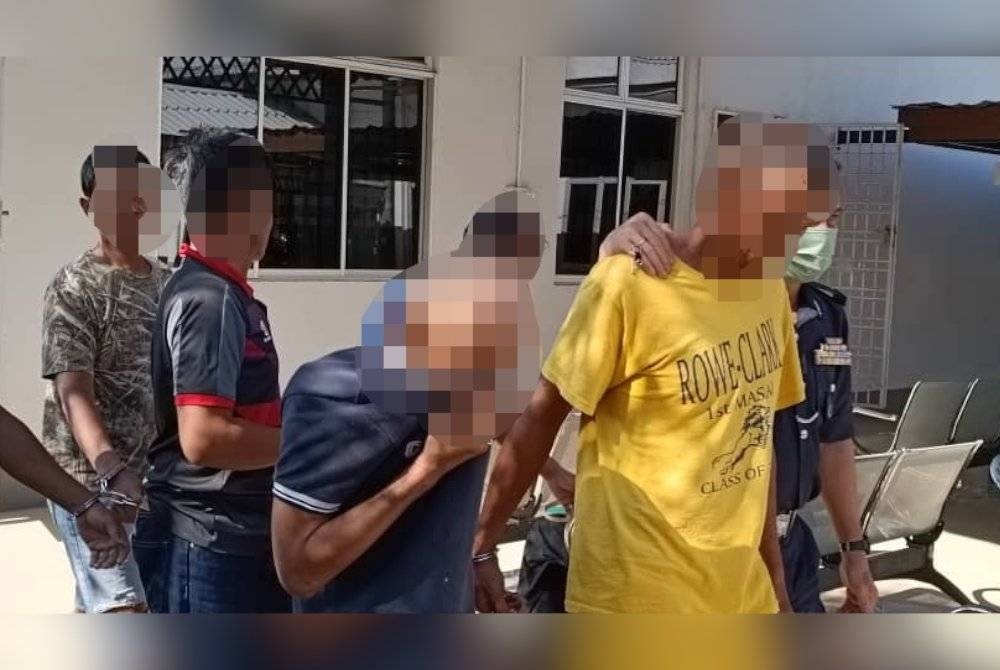 Suspek (tengah) ketika dibawa ke mahkamah pada Khamis bagi mendapat perintah tahanan reman.
