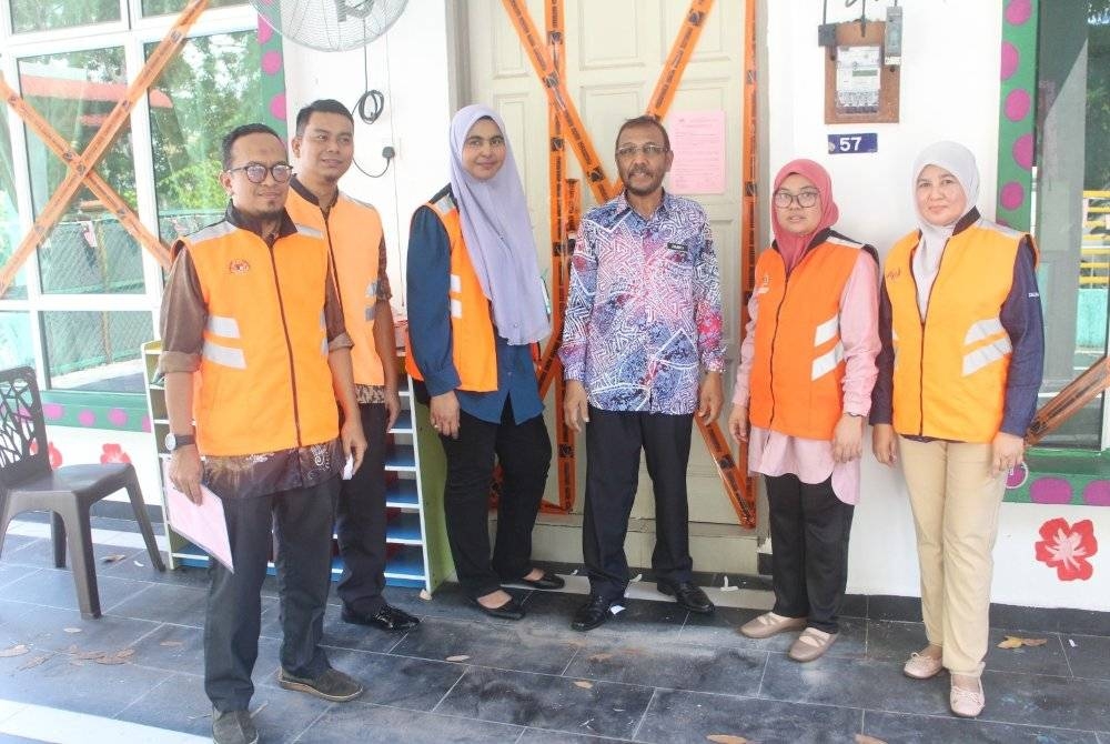Zulkifli (empat dari kiri) bersama staf JKM Melaka selepas menyita taska di Taman Pertan Jaya.