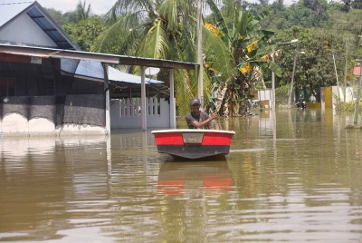 Penduduk, Shaarani Zakaria, 56, menaiki sampan di hadapan rumahnya pada tinjauan di Batu 9, Jalan Changkat Jong, Teluk Intan.- Foto: Bernama