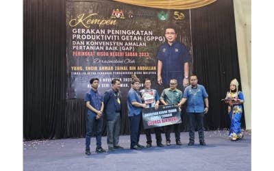 Ahmad Zainal (tiga dari kiri) menyampaikan penerima Anugerah Kebun Tanam Semula Terbaik kepada seorang peserta pekebun kecil getah sempena perasmian Kempen GPPG di Tauran, Sabah pada Rabu.
