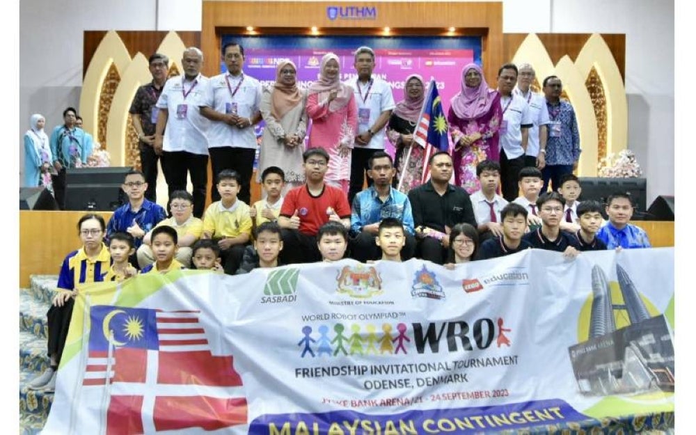 Fadhlina (berdiri, lima dari kiri) bersama Pasukan Robotik KPM yang memperoleh pingat emas dalam pertandingan WRO di Denmark, September lalu.