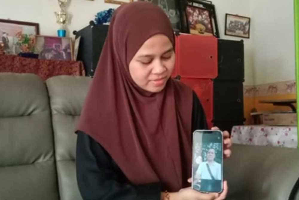 Fatin menunjukkan menunjukkan gambar Allahyarham bapanya.