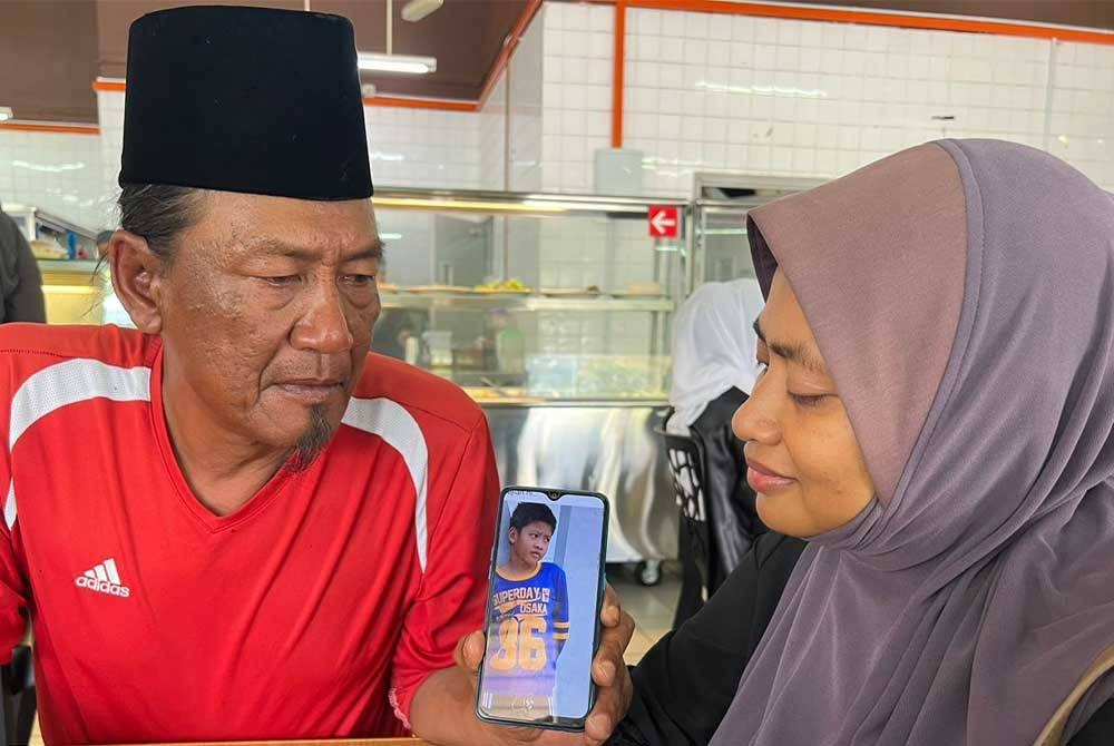 Johan dan isteri menunjukkan gambar Mohammad Adam Dani.