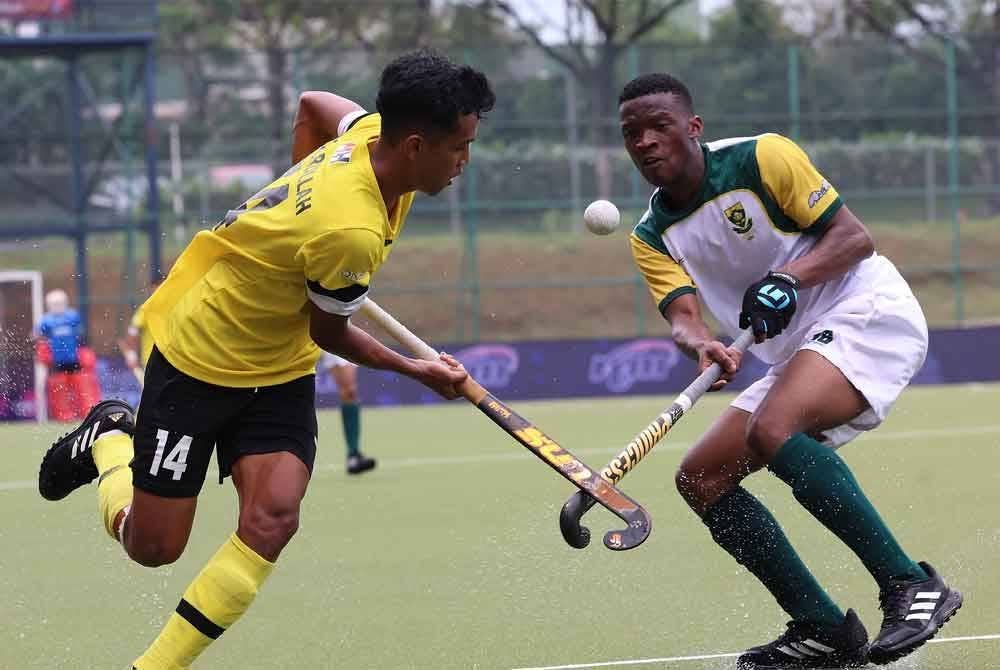 Pemain Young Tigers, Che Nur Aqilrullah Che Mohd Khairulzi Anwar dicabar pemain Afrika Selatan Thabang Jeyi dalam perlawanan penentuan tempat ketujuh dan kelapan SOJC 2023 di Stadium Hoki Taman Daya, pada Jumaat. - Foto Bernama