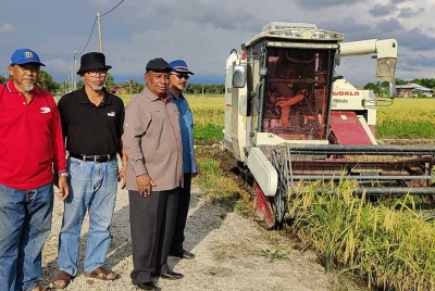 Abdul Razak (dua dari kanan) meninjau kerja-kerja penuaian padi di Parit 3 Ban 3, Sungai Burung di sini pada Jumaat.