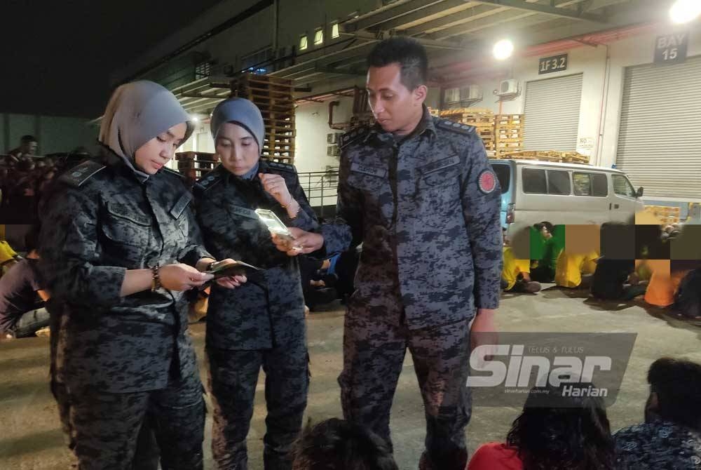JIM Selangor menjalankan pemeriksaan warga asing yang ditahan dalam serbuan di sebuah gudang barangan di Seksyen 22, Shah Alam pada Sabtu.