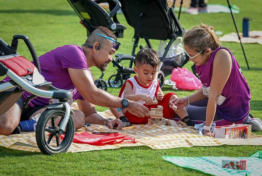 Azwar Hashim dan isterinya, Emylia Rosly melayani anak mereka, Ethan Daniel, 3, selepas menamatkan Kasih Family Fun Walk sempena Sambutan November Bulan Keluarga Kebangsaan bertemakan "Keluarga Harmoni, Negara Madani" di Dataran Putrajaya hari ini.