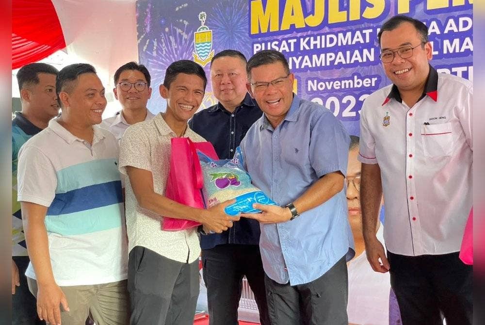 Saifuddin (dua dari kanan) menyerahkan bakul makanan penduduk sekitar Dun Kebun Bunga sempena sambutan Deepavali pada Sabtu.