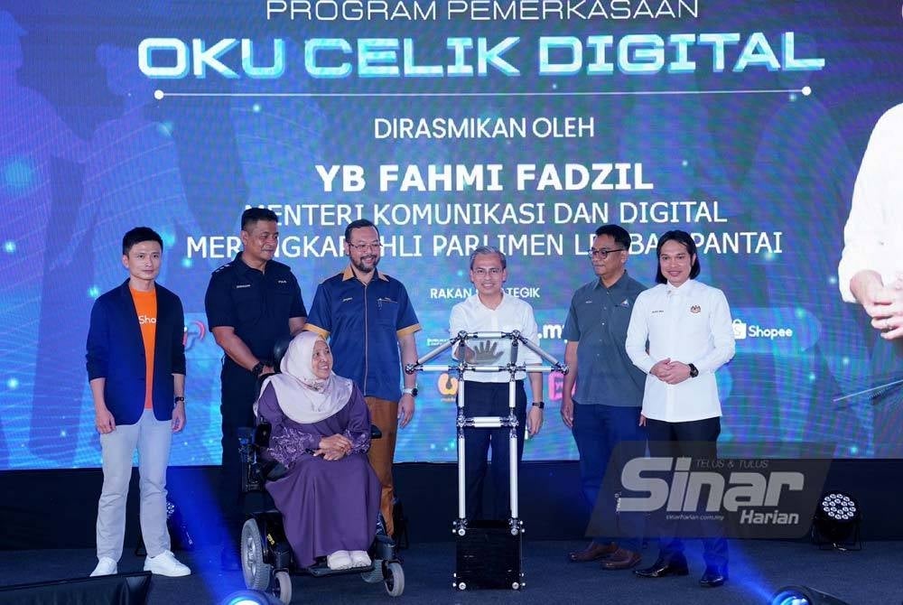Fahmi (tiga dari kanan) menyempurnakan gimik pelancaran Program Pemerkasaan OKU Celik Digital yang berlangsung di Pusat Komuniti IWK Eco Park pada Ahad. - Foto Sinar Harian / MOHD HALIM ABDUL WAHID.
