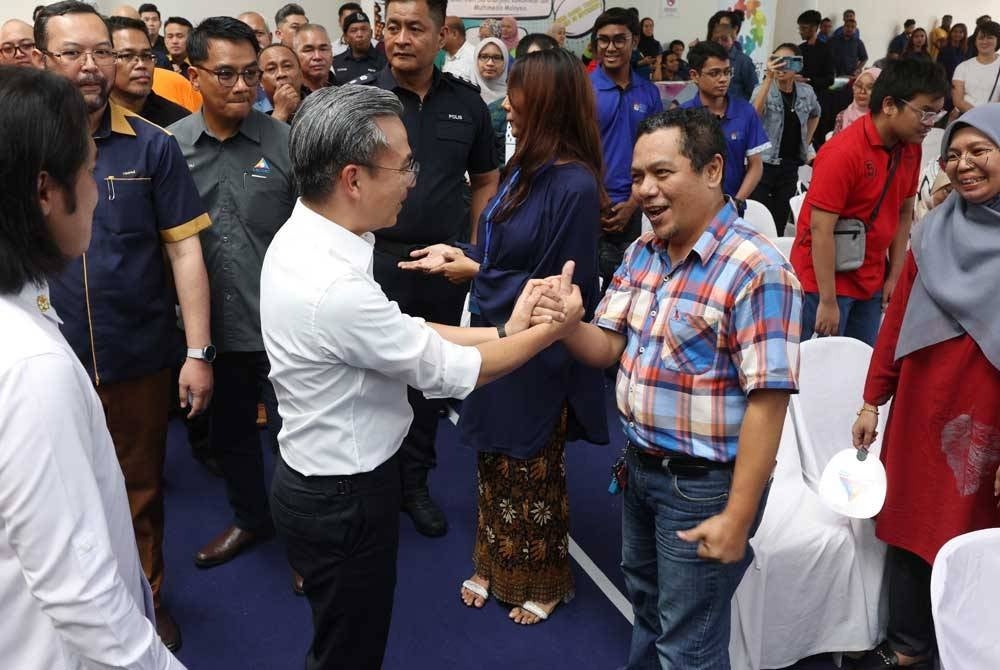 Fahmi beramah mesra dengan pengunjung ketika menghadiri Majlis Perasmian Program Pemerkasaan OKU Celik Digital di Pusat Komuniti IWK Eco Park hari ini. - Foto Bernama