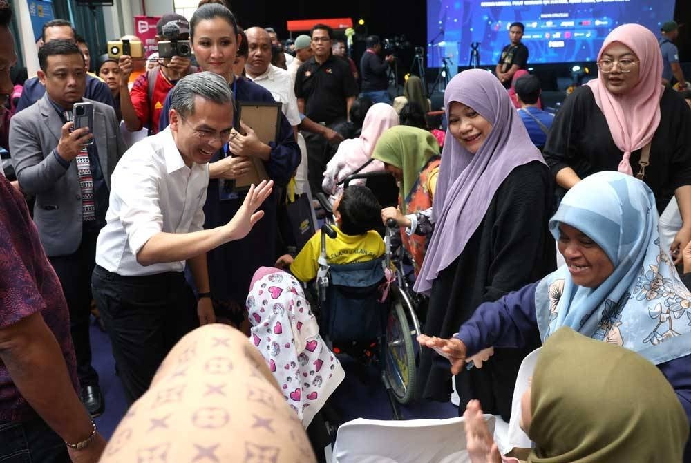 Fahmi beramah mesra dengan pengunjung ketika menghadiri Majlis Perasmian Program Pemerkasaan O KUCelik Digital di Pusat Komuniti IWK Eco Park hari ini. - Foto Bernama