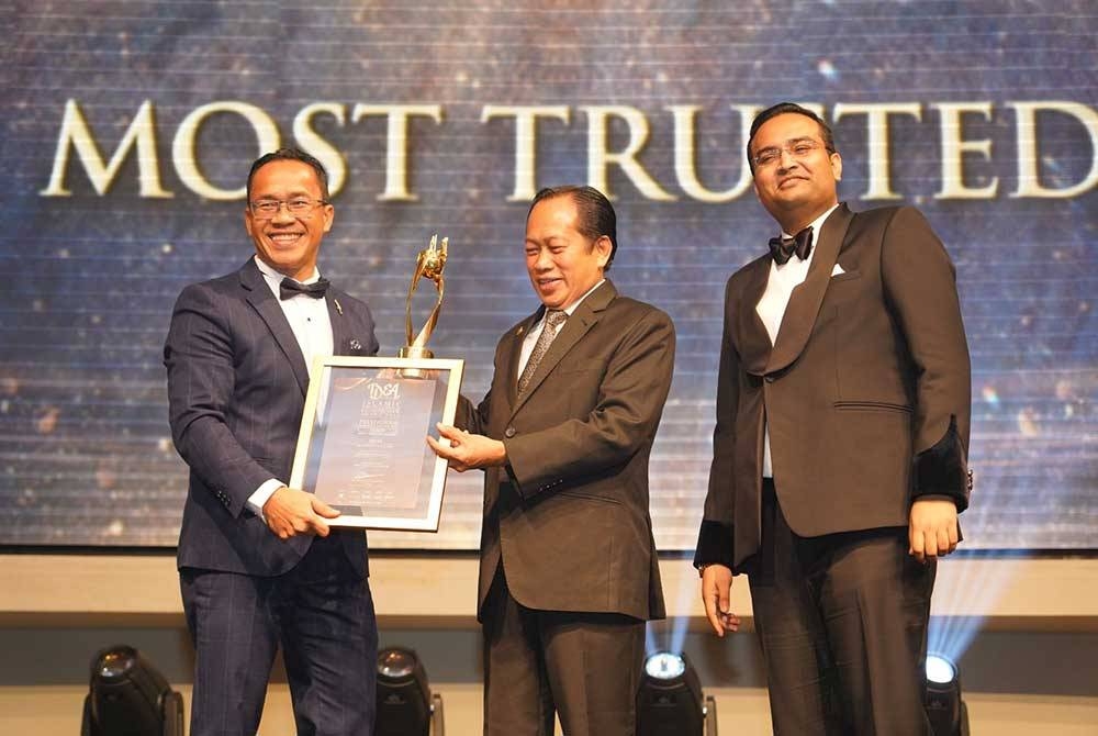 Ahmad (tengah) menyampaikan anugerah &#039;Most Trusted Brand’ kepada Ahmad Najib (kiri) di Islamic Distinguished Entrepreneur Award (IDEA Award) 2023 yang diadakan di Kuala Lumpur, baru- baru ini.